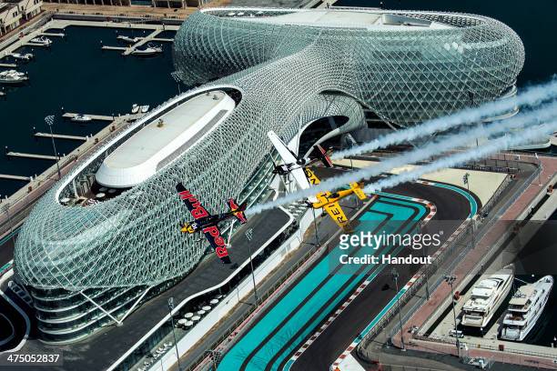 In this handout image provided by Red Bull, Kirby Chambliss , Michael Goulian of the United States and Nigel Lamb of Great Britain fly over the Yas...