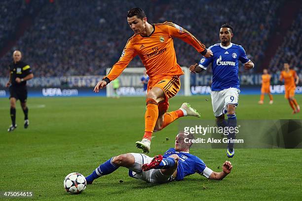 Cristiano Ronaldo of Madrid eludes Benedikt Hoewedes and Kevin-Prince Boateng of Schalke during the UEFA Champions League Round of 16 first leg match...