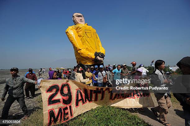 Lapindo mudflow victims bring a big statue of Aburizal Bakrie at a protest during the ninth anniversary of the Lapindo mudflow eruption on May 29,...