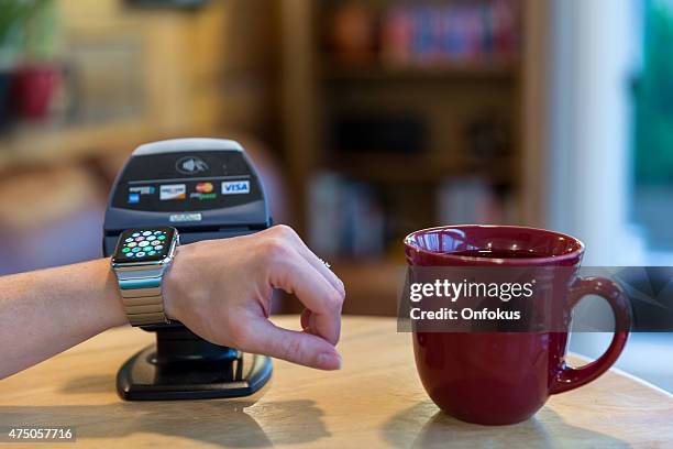 woman paying using apple watch and electronic reader - apple inc stockfoto's en -beelden