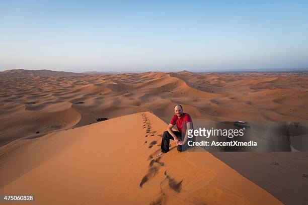 tourist on the erg chebbi dunes, moroccan sahara desert - merzouga stockfoto's en -beelden