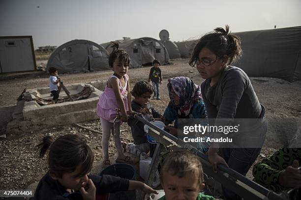 Syrian women and girls fill the buckets with water in Suruc district of Sanliurfa, Turkey on May 28, 2015. Syrian refugees fled their home due to the...