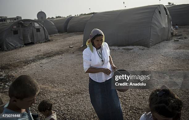 Syrian woman goes to fill the buckets with water in Suruc district of Sanliurfa, Turkey on May 28, 2015. Syrian refugees fled their home due to the...
