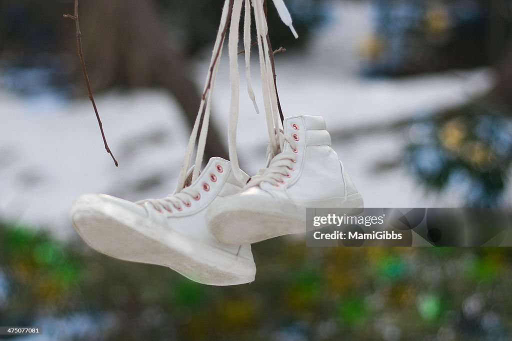 Hanging up the white sneakers at the forest