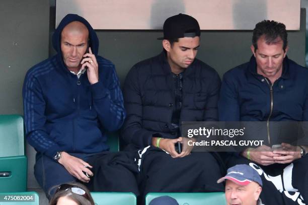 Former French football player Zinedine Zidane and his son Enzo sit in the stands during Croatia's Mirjana Lucic-Baroni and France's Alize Cornet's...