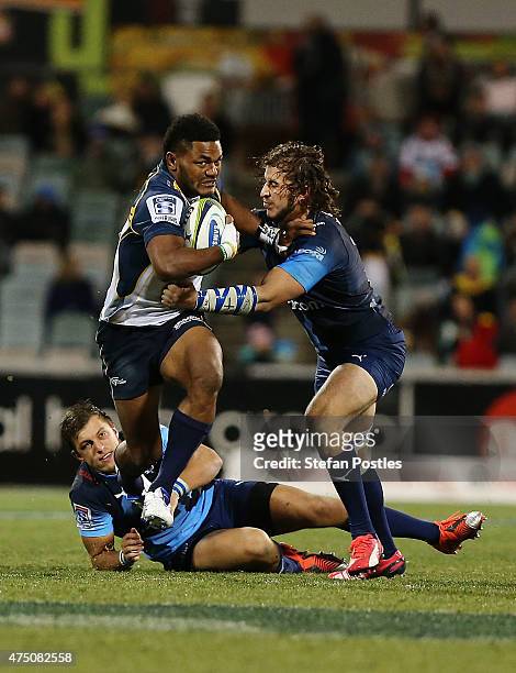 Henry Speight of the Brumbies pushes off two Bulls players to score a try during the round 16 Super Rugby match between the Brumbies and the Bulls at...