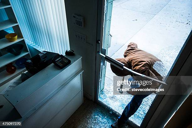 robber using a sledgehammer, - up on a roof stockfoto's en -beelden