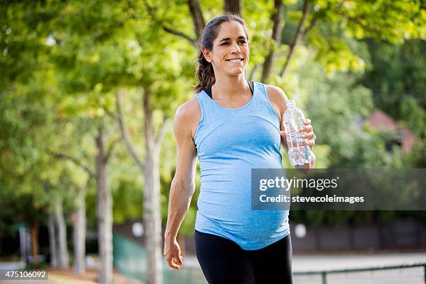 pregnant woman walking and carrying a bottle of water. - speed walking stock pictures, royalty-free photos & images