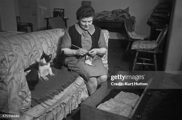One of the older prisoners, with her pet cats in her cell at Holloway Prison, north London, March 1947. Having completed penal servitude, she is now...