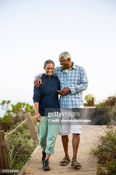 couple walking on boardwalk. - african american man walking stock pictures, royalty-free photos & images