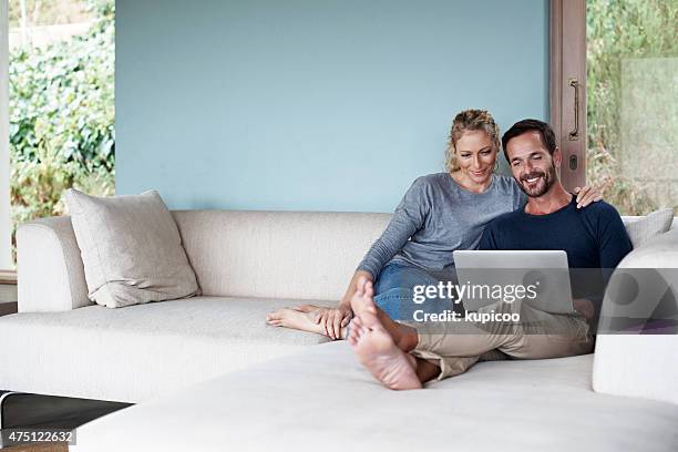 we're enjoying our weekend surfing - ouder-volwassenen-koppel stockfoto's en -beelden