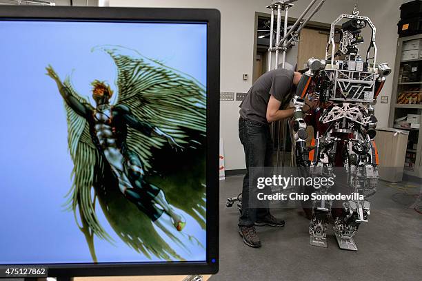 Virginia Tech graduate student Coleman Knabe work to repair an actuator on the 'hip' of the ESCHER robot at the TREC Lab where the team's computers...