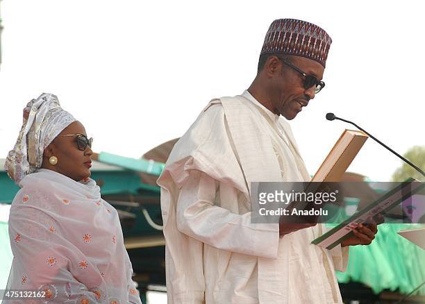 Nigerian President Muhammadu Buhari takes his oath of office with his wife Aisha Buhari, the new first lady of Nigeria during his inauguration...