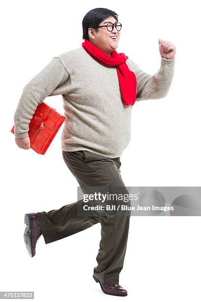 excited young man with chinese new year's gift running - 25 year man ストックフォトと画像