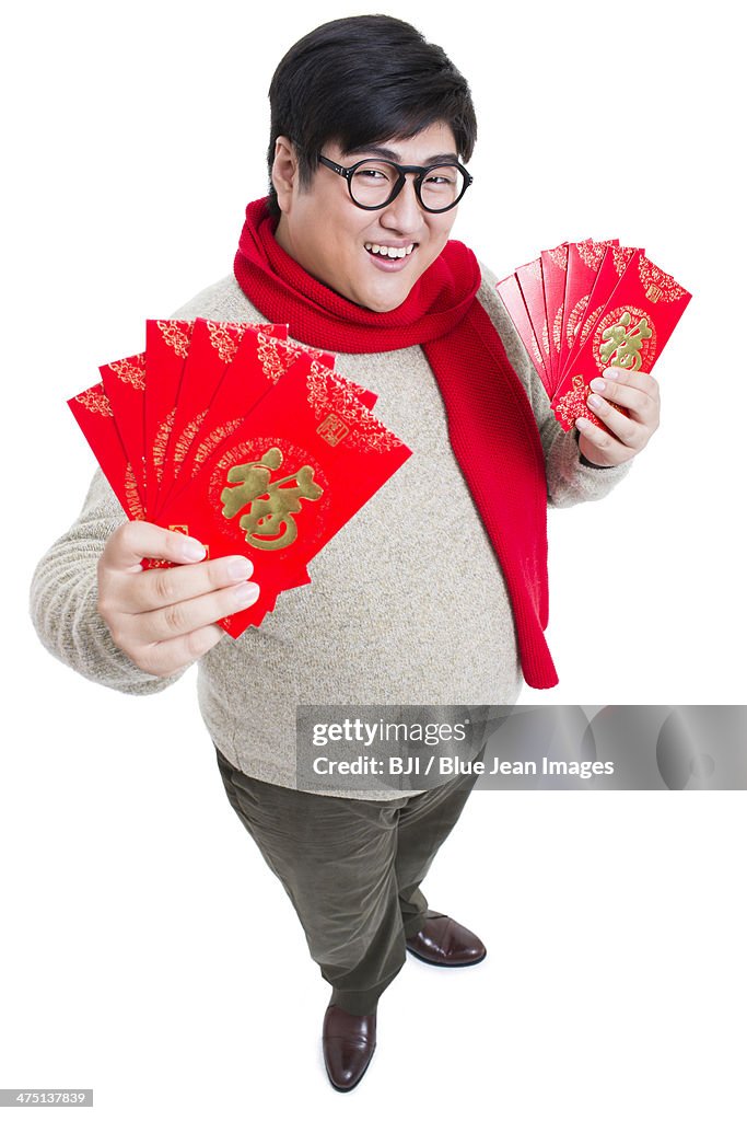 Chubby young man with red packets celebrating Chinese New Year