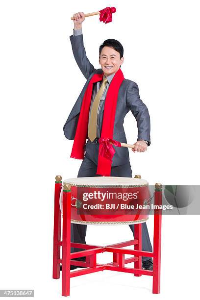 cheerful businessman playing traditional chinese red drum - bedug stock pictures, royalty-free photos & images