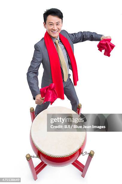 cheerful businessman playing traditional chinese red drum - bedug stock pictures, royalty-free photos & images