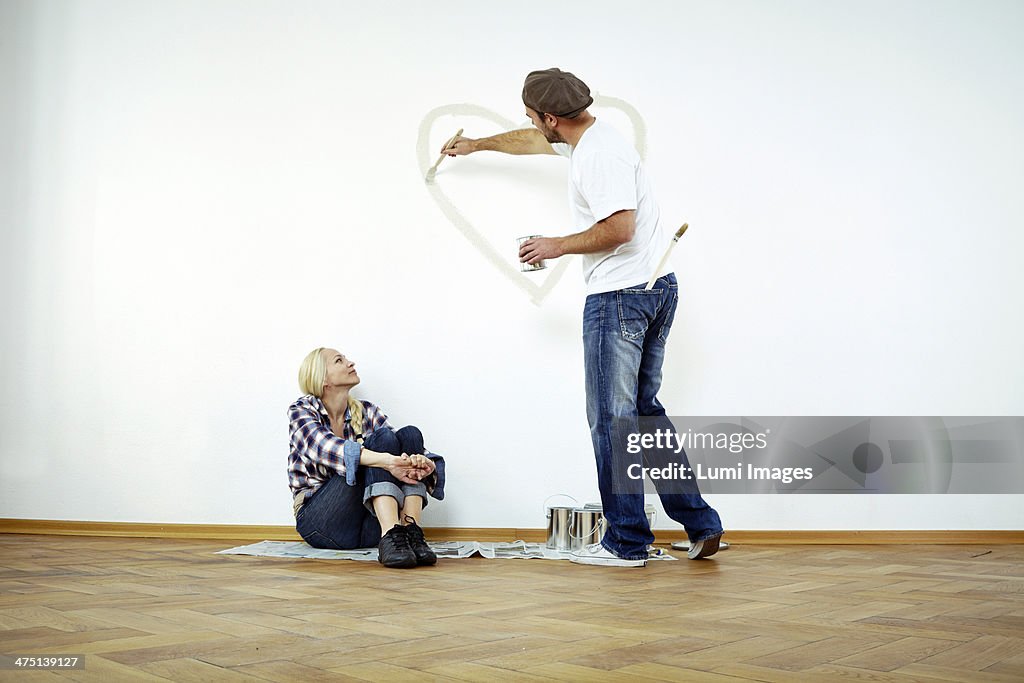 Man painting heart shape on the wall, woman is watching, Munich, Bavaria, Germany