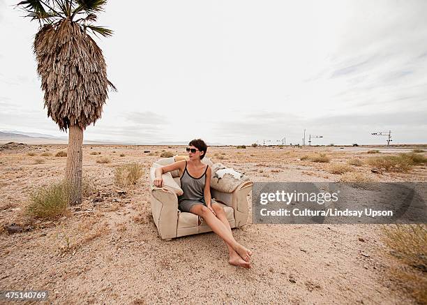 Young woman relaxing in armchair in desert