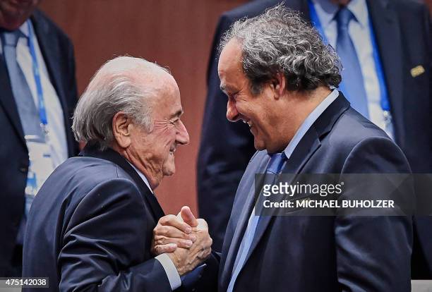 President Sepp Blatter shakes hands with UEFA president Michel Platini after being re-elected following a vote to decide on the FIFA presidency in...