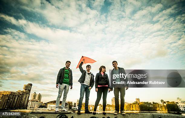 four friends with one man holding kite, russia - kite toy stock-fotos und bilder