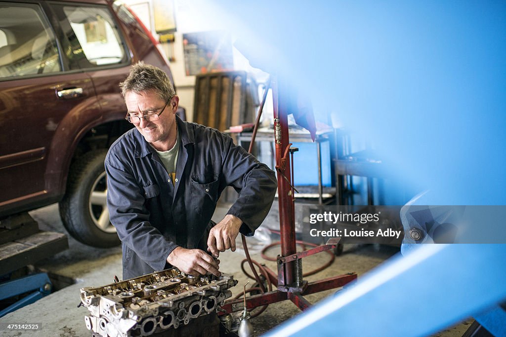 Mechanic working on car parts in garage