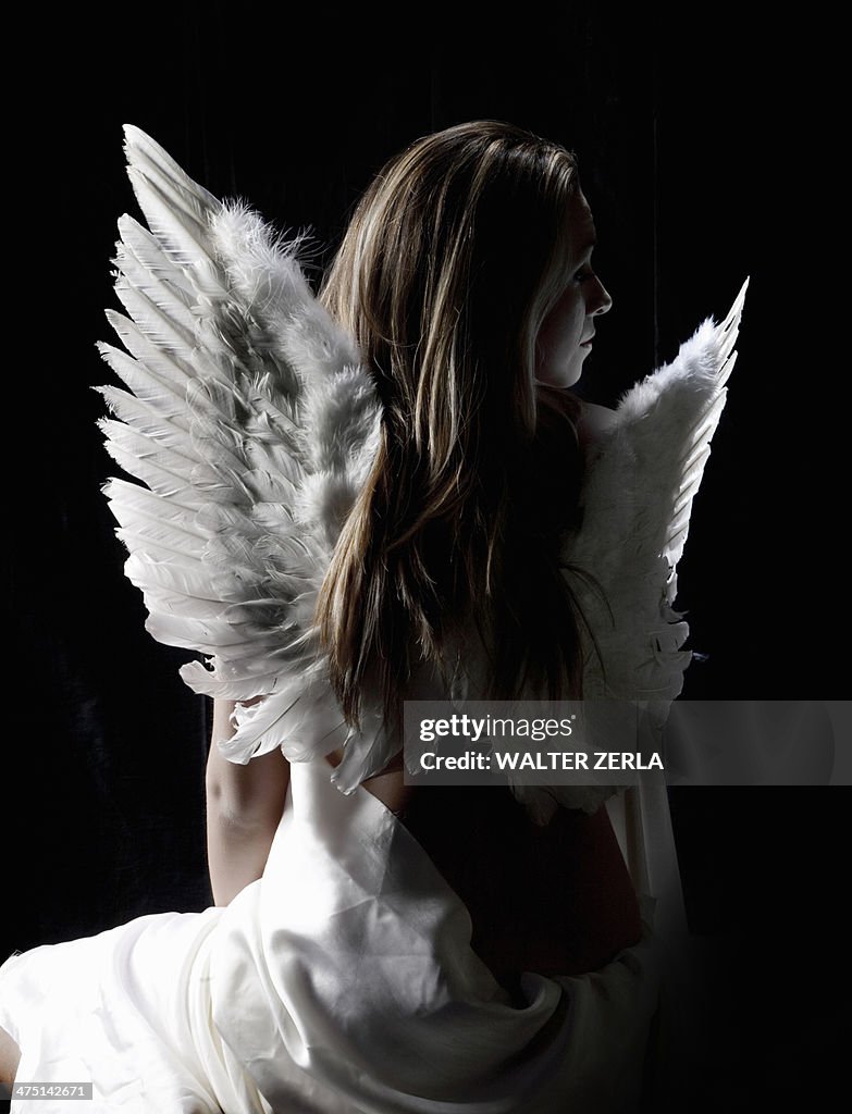 Studio portrait of pensive woman wearing angel wings