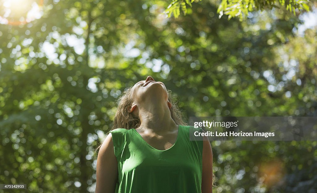 Teenage girl wearing green top looking up, Prague, Czech Republic