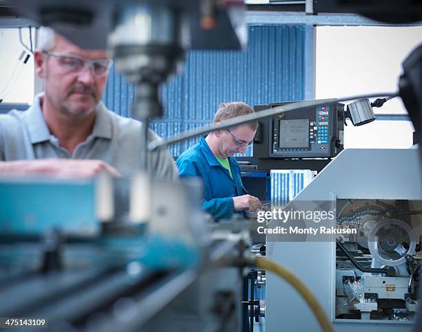 lathe operators working in factory - drehmaschine stock-fotos und bilder