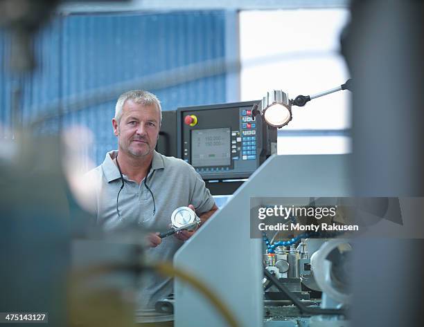 lathe operator working in factory, portrait - drehmaschine stock-fotos und bilder