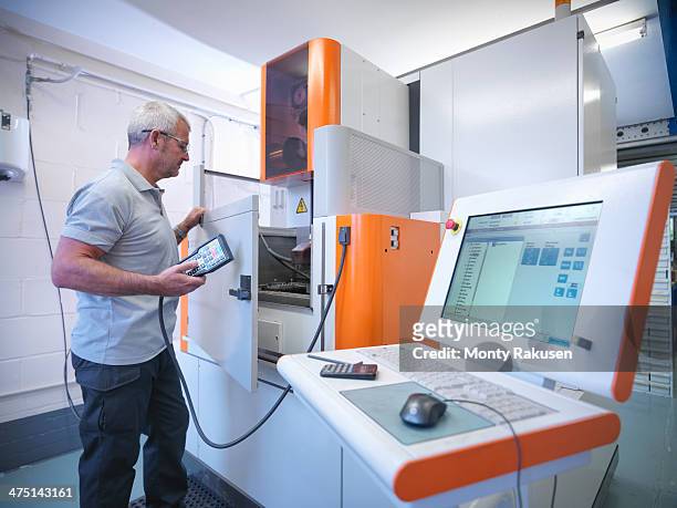 engineer operating wire erosion machine in factory - bishop's stortford stock pictures, royalty-free photos & images