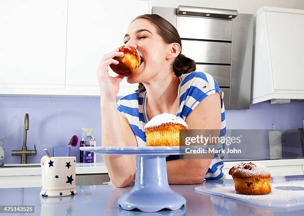 young woman eating muffin - muffin top stock-fotos und bilder