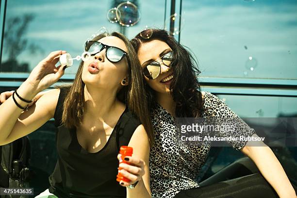 two young woman blowing bubbles - friend mischief stock pictures, royalty-free photos & images