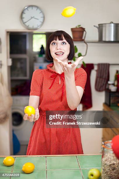 young woman in kitchen juggling lemons - juggling imagens e fotografias de stock