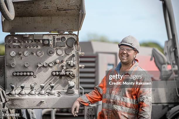 drilling rig worker in hard hat and workwear, smiling - drillinge stock pictures, royalty-free photos & images