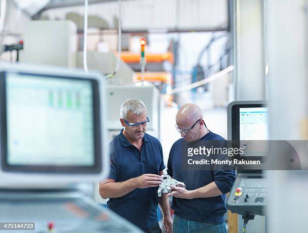 engineers inspecting complex metal component in factory - quality control stock pictures, royalty-free photos & images