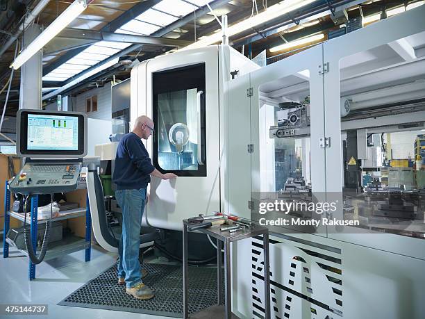 engineer at computer numerical controlled lathe (cnc) in factory - cnc stock pictures, royalty-free photos & images