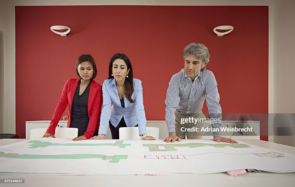 Three architects with blueprints