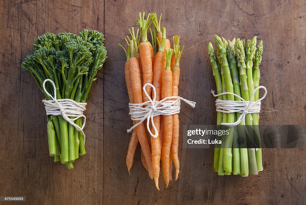 Bunches of carrots, broccoli and asparagus tied with string, still life