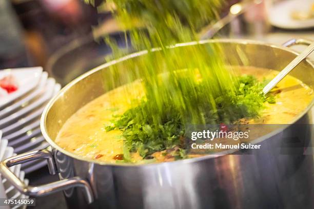 fresh herbs being poured into saucepan - schwaben stock-fotos und bilder