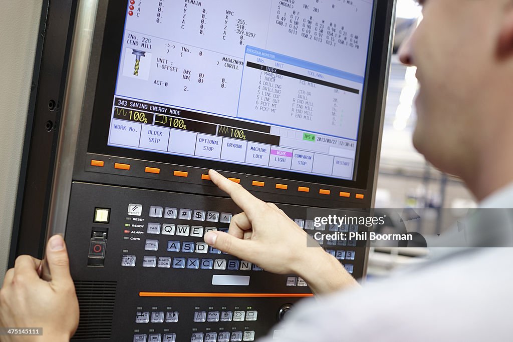 Worker checking computer monitor in engineering factory