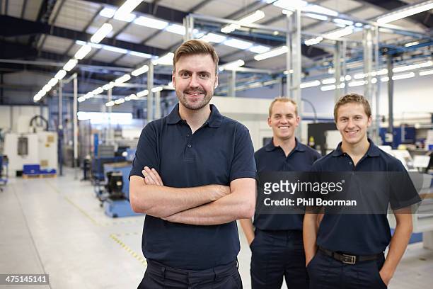 portrait of three workers in engineering factory - work accountability stock-fotos und bilder