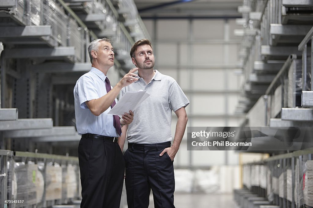 Worker and manager checking products in engineering warehouse