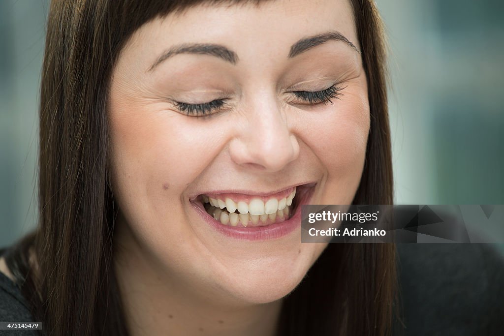 Young woman laughing, eyes closed