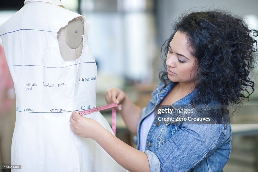 Fashion design student measuring in class