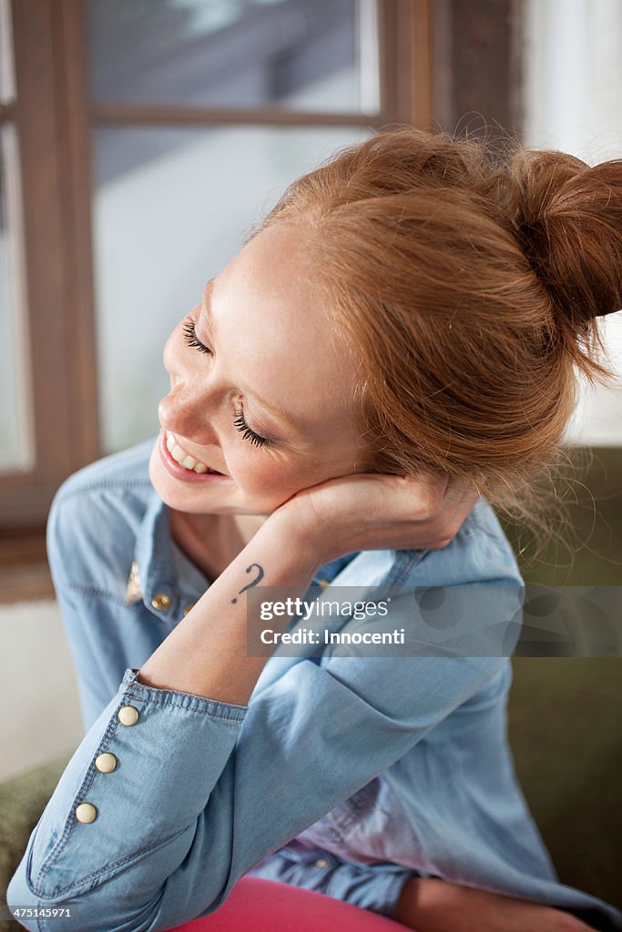 Young woman with question mark tattoo smiling
