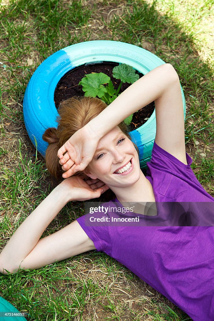 Woman lying on tire, high angle