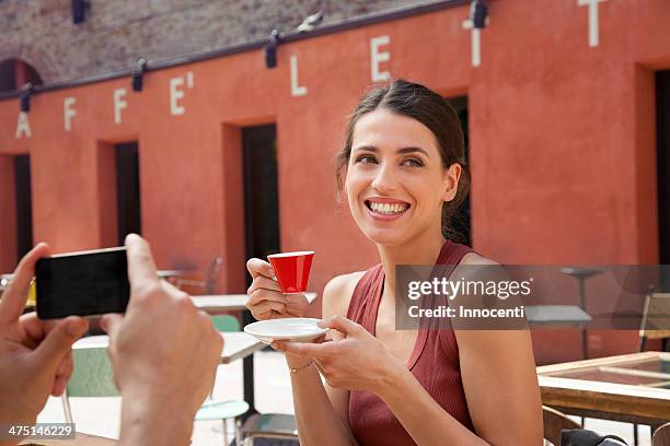 man photographing woman outside cafe, florence, tuscany, italy - italian woman stock-fotos und bilder