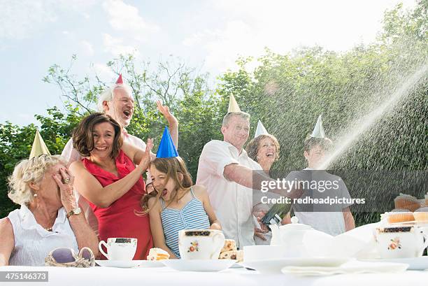 family celebrating birthday, man opening champagne - spraying champagne stock pictures, royalty-free photos & images