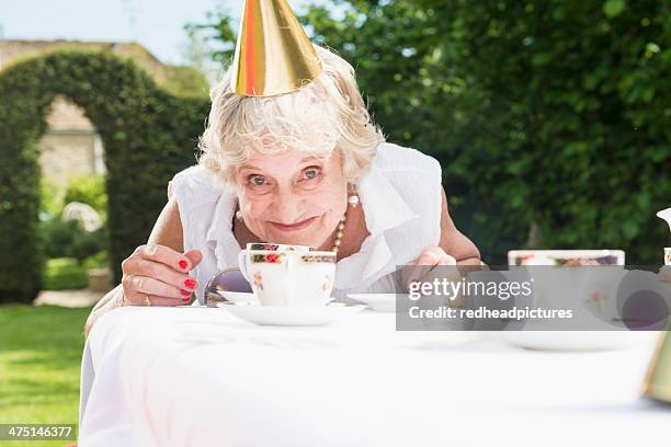 senior woman wearing party hat looking at camera, smiling - fest 2013 day 1 stock-fotos und bilder